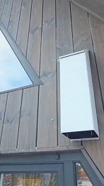 Наружный вытяжной воздуховод на фасаде частного дома с деревянной обшивкой